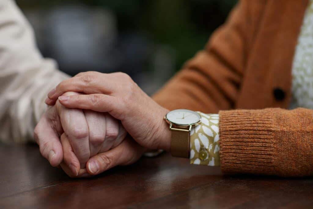 elderly couple holding hands